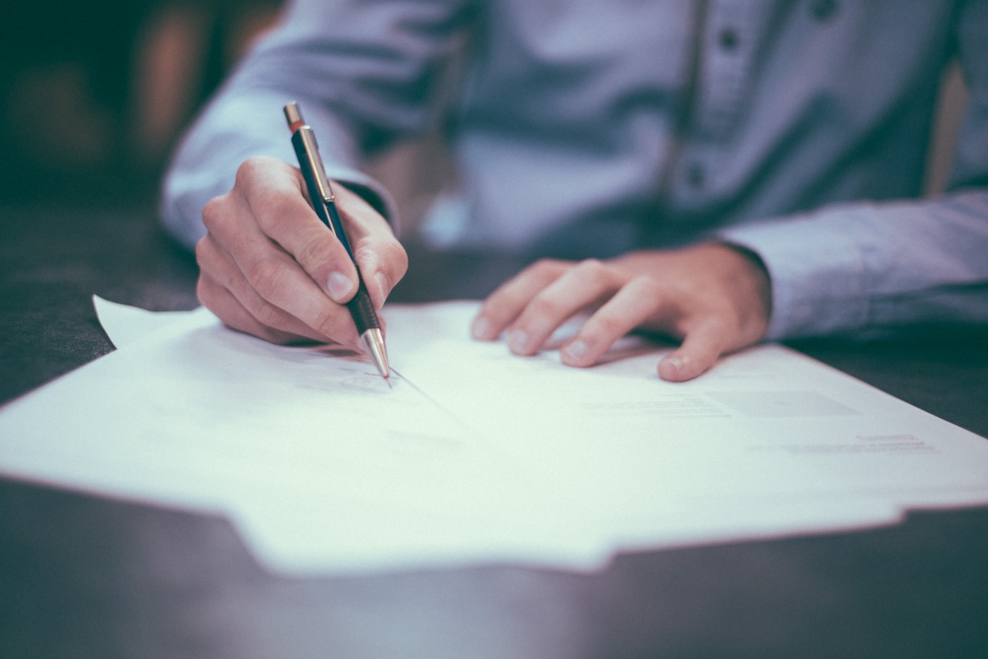 Hand signing off a set of printed financial documents